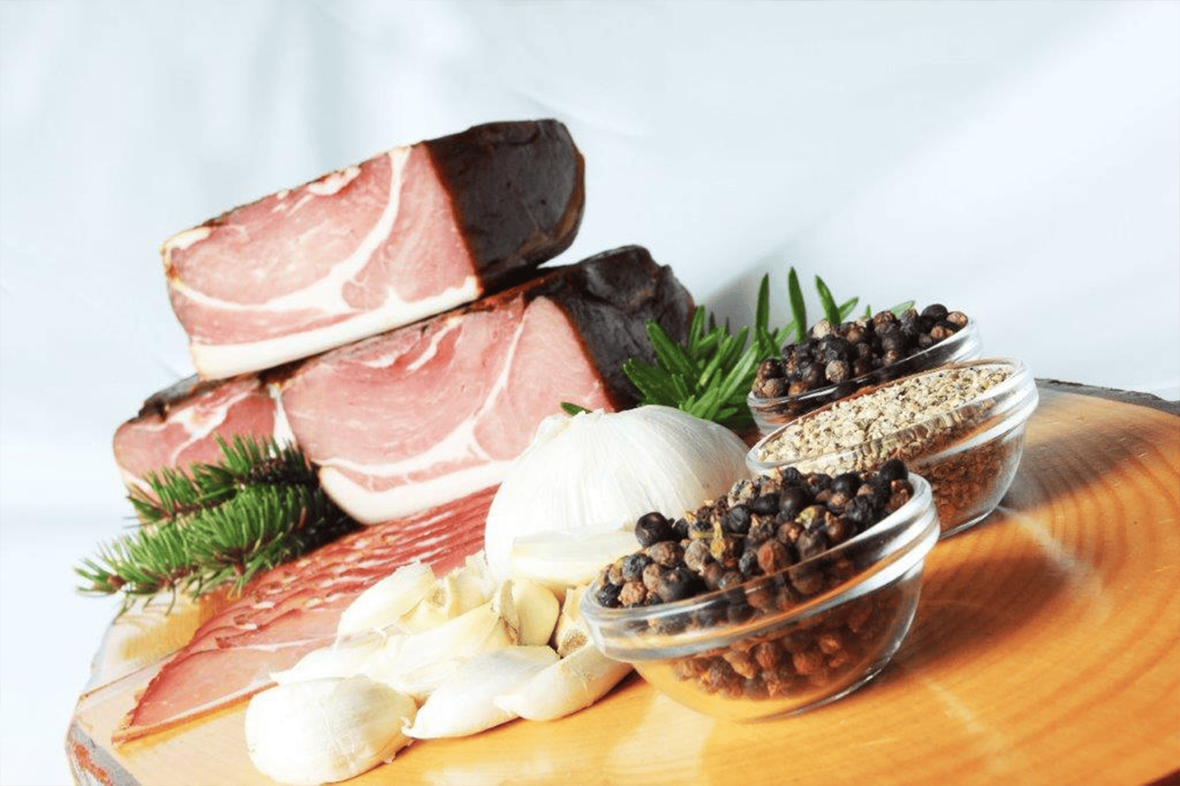 Frisches Schweinefleisch mit Gewürzen und Kräutern auf Holzplatte, perfekt für Rezepte und Kochkunst.