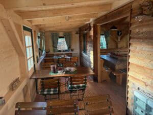 Gemütliches Interieur der Hirsch-Hütte mit Klozbüchern und rustikalem Holzdesign.