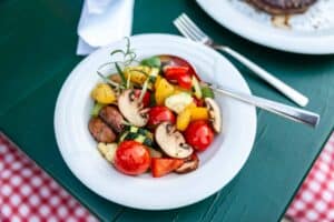 Frischer Gemüsesalat mit Tomaten und Pilzen, perfekt für Feinkostliebhaber.